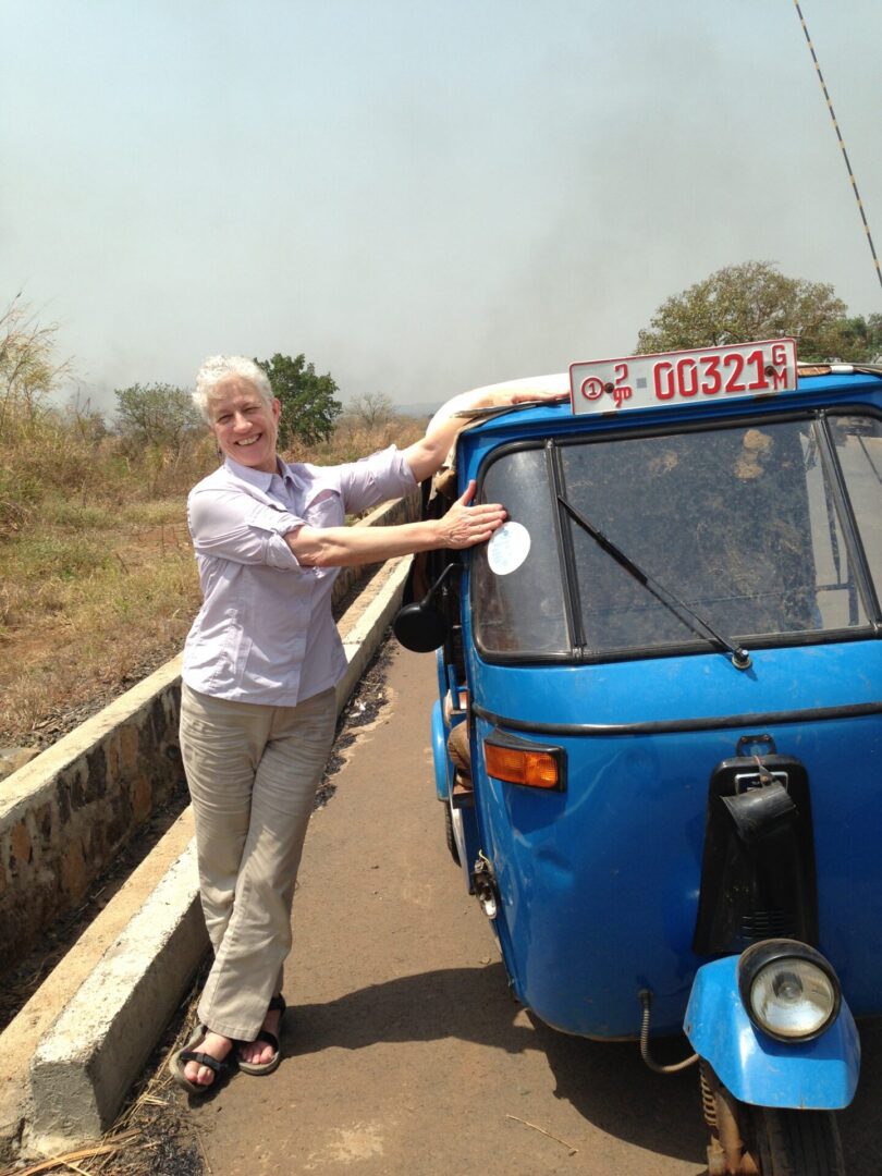Smiling woman with blue three-wheeler