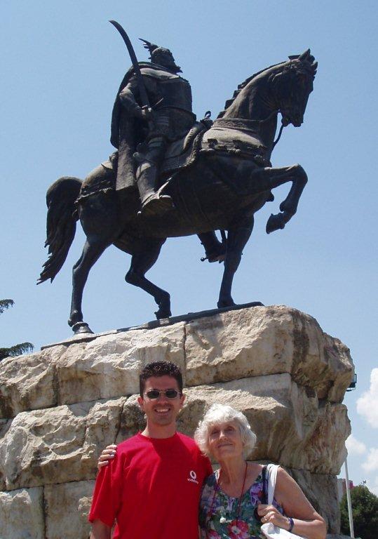 Man and woman in front of equestrian statue