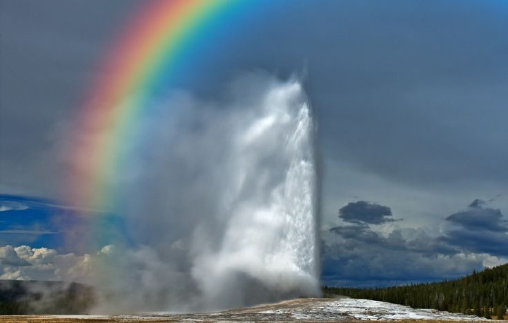 Stunning rainbow arches over geyser eruption