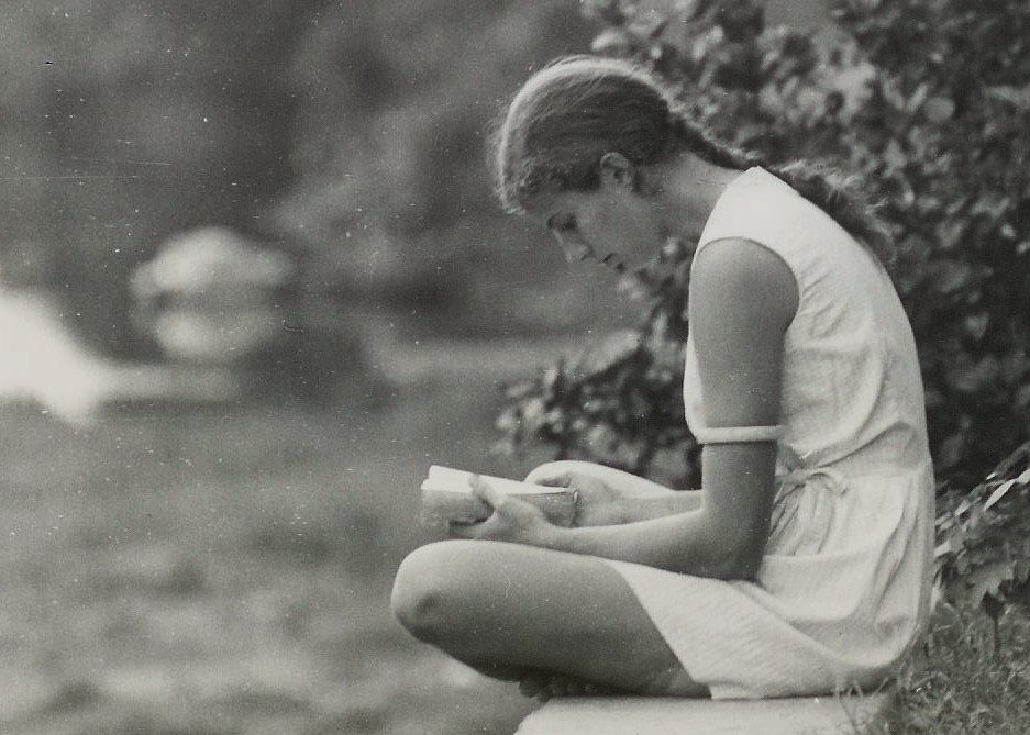 Girl sitting outdoors with book