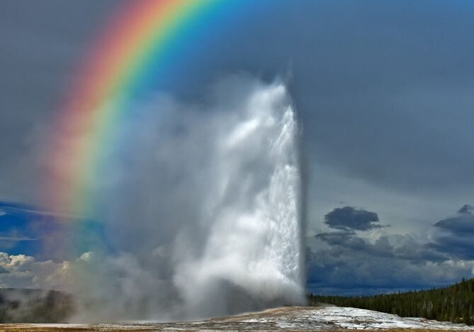 Stunning rainbow arches over geyser eruption