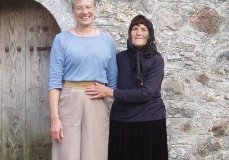 Albaanian woman and American woman standing by stone tower